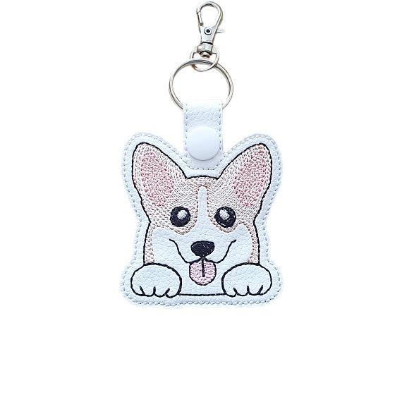 Kawaii Corgi keyring made from white faux leather, with embroidered perky ears, sweet paws, pink tongue and silver metal hardware.