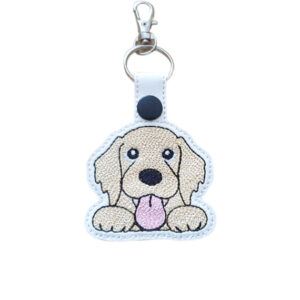 Kawaii Golden Retriever keyring made from white faux leather, with embroidered floppy ears, sweet paws, pink tongue and silver metal hardware.