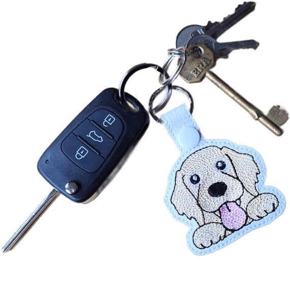 Kawaii Golden Retriever keyring attached to a set of keys, showing the embroidered dog design in everyday use.