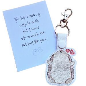 Embroidered Kawaii Hedgehugs keyring with two red hearts, shown beside a matching keepsake card with a loving hedgehog gift message.
