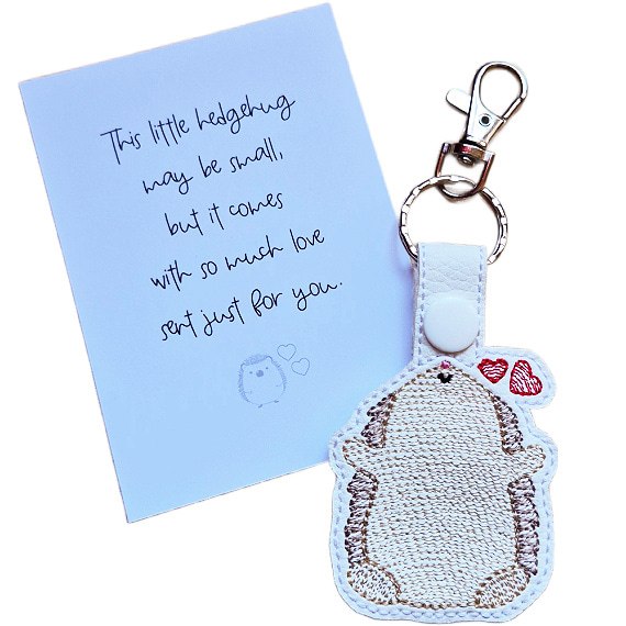 Embroidered Kawaii Hedgehugs keyring with two red hearts, shown beside a matching keepsake card with a loving hedgehog gift message.