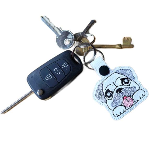 Kawaii Pug keyring attached to a set of keys, showing the embroidered dog design in everyday use.