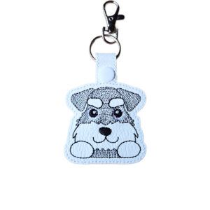 Kawaii Schnauzer keyring made from white faux leather, with embroidered fluffy brows, whiskery face, sweet paws and silver metal hardware.