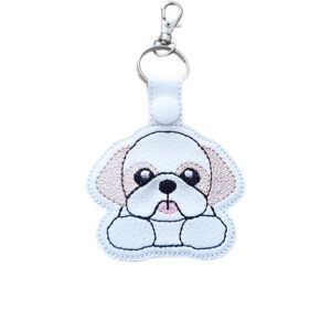 Kawaii Shih Tzu keyring made from white faux leather, with embroidered floppy ears, sweet face, tiny tongue and silver metal hardware.