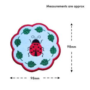 Ladybird candle coaster size guide showing the embroidered scalloped coaster measuring approximately 98mm x 98mm.