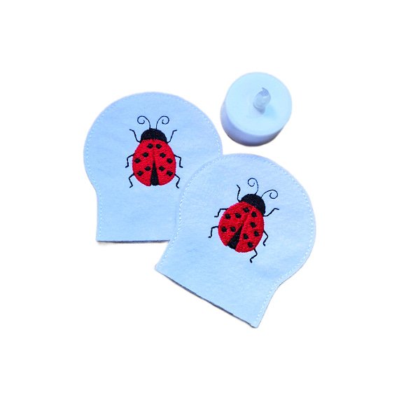 Set of two embroidered ladybird tealight covers made from soft felt, shown with an LED tealight for a cheerful garden inspired display.