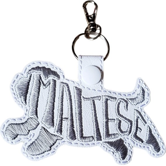 White embroidered Maltese word art keyring made from faux leather, with stitched breed lettering and silver metal hardware.