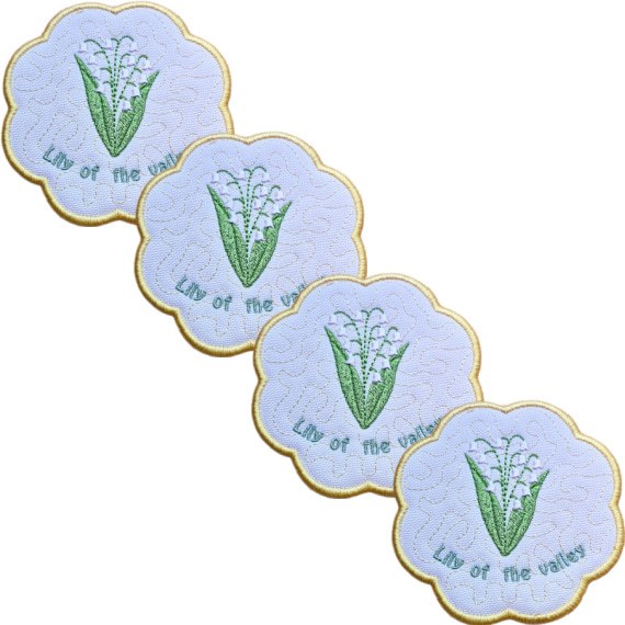 Set of four embroidered May birth flower candle coasters, each with Lily of the Valley flowers, stitched text, background detail and a scalloped border.