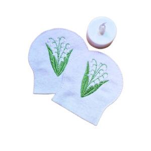 Embroidered May birth flower tealight covers on white felt, with Lily of the Valley flowers and green leaves, shown beside a battery operated LED tealight.