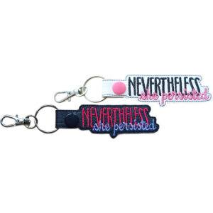 Embroidered Nevertheless She Persisted keyring in faux leather, with bold stitched quote lettering on black and white backgrounds and sturdy metal hardware.