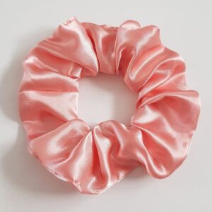 Pale pink satin scrunchie with a soft sheen on a white background.
