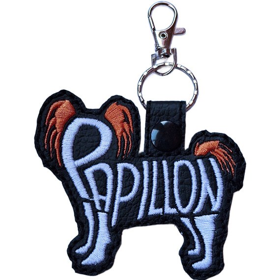 Black embroidered Papillon word art keyring made from faux leather, with stitched breed lettering and silver metal hardware.