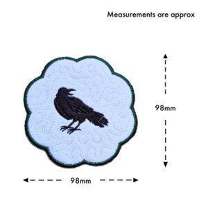 Raven candle coaster size guide showing the embroidered scalloped coaster measuring approximately 98mm x 98mm.