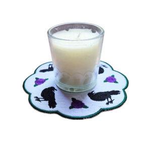 Embroidered raven candle mat with striking black ravens, delicate rose details, scalloped edging and gothic inspired decorative styling.
