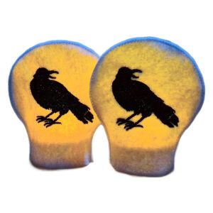 Lit raven tealight covers glowing warmly over LED tealights, showing striking black raven silhouettes on soft felt for a moody gothic inspired display.