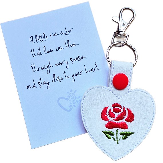 Embroidered rose heart keyring in white faux leather with red snap fastening and silver key clip, displayed beside a white keepsake card with heartfelt rose wording.