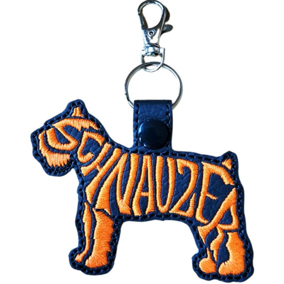 Black embroidered Schnauzer word art keyring with orange stitched breed lettering and silver metal hardware.