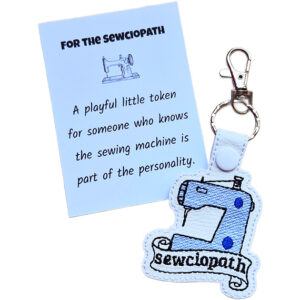 White faux leather Sewciopath sewing machine keyring shown with a keepsake card reading 'For the Sewciopath'.