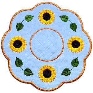 Close up of an embroidered sunflower candle mat with yellow sunflowers, green leaves, circular centre and warm golden scalloped border.
