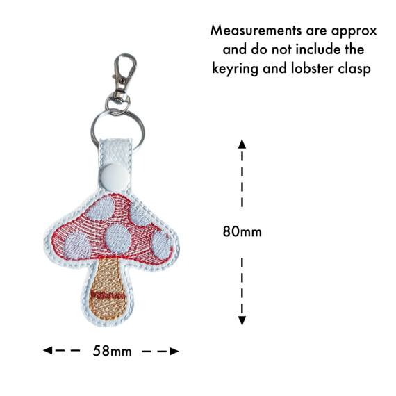 White faux leather toadstool mushroom keyring with embroidered red and white design, shown with approximate measurements of 80mm x 58mm excluding the keyring and clasp.