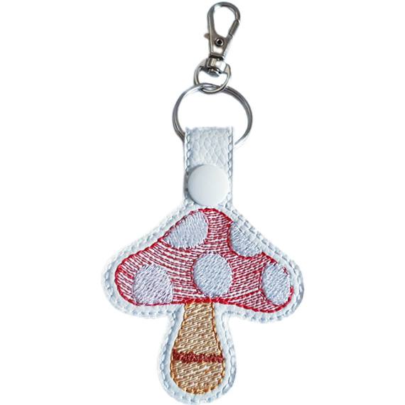 White faux leather toadstool mushroom keyring with a red spotted cap, stitched stem detail and silver lobster clasp.