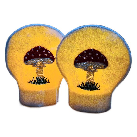 Lit toadstool tealight covers glowing warmly over LED tealights, showing embroidered red toadstools on soft felt for a cosy woodland inspired display.