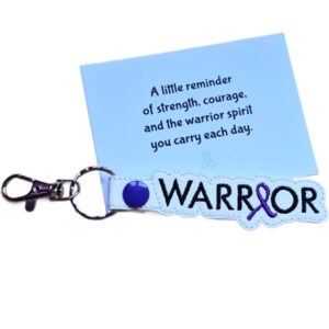 Embroidered Warrior awareness ribbon keyring made from faux leather, shown with a keepsake card featuring a message of strength, courage and warrior spirit.