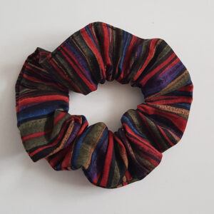 Dark boho striped cotton scrunchie with red, navy, olive and brown stripes on a white background.