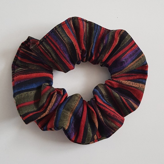 Dark boho striped cotton scrunchie with red, navy, olive and brown stripes on a white background.