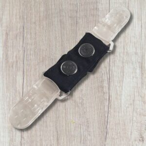 A row of handmade double ended clothing clips in bright colours including pink, red, orange, yellow, green, turquoise, blue, purple and black, with clear plastic clips at each end.