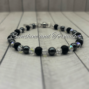 Handmade gemstone bracelet featuring matte black obsidian beads, polished hematite beads, sparkling Czech crystal beads and a detailed silver-tone cross charm on a secure clasp fastening.