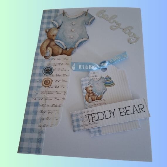 New Baby Boy Card with teddy Bears with blue baby grow, tag with blue ribbon reading "its a boy"