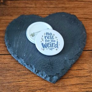 Funny weird badge design with the phrase 'No rest for the weird' in playful lettering, decorated with small heart, star and sparkle accents.