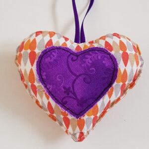 Orange And Purple Hanging Heart Decoration On A White Background