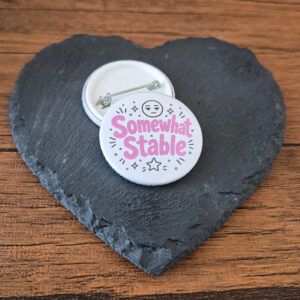 Funny relatable badge design with the phrase 'Somewhat stable' in playful lettering, decorated with small star and sparkle accents.