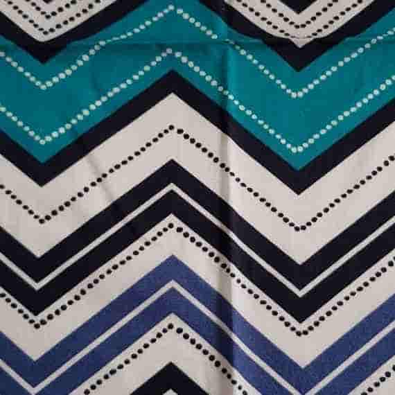 Geometric chevron fabric with teal, blue, black and cream zigzag stripes and dotted details.
