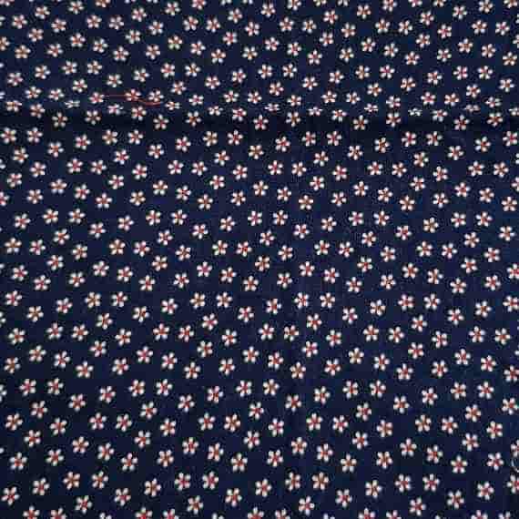 Dark navy fabric with small white daisy flowers, red centres and a simple repeating floral pattern.