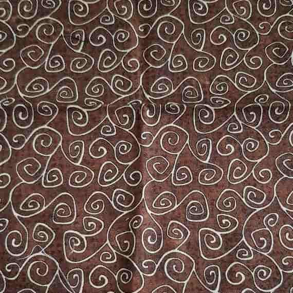 Brown patterned fabric with cream spiral swirls and abstract decorative line details.