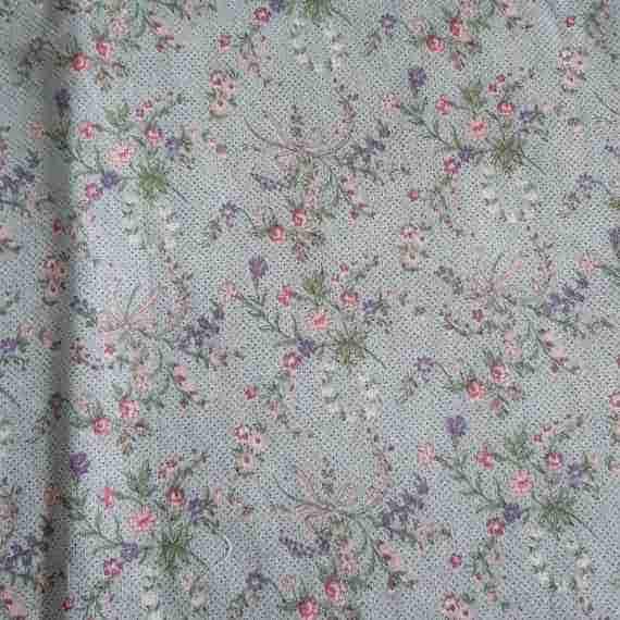 Pale blue vintage floral fabric with soft pink and purple flowers, green leafy sprigs and delicate butterfly details.