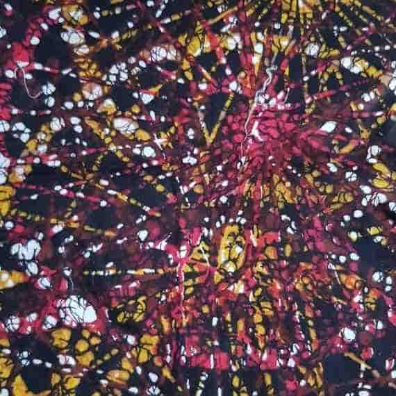 Earthy abstract batik fabric with red, mustard yellow, brown, black and white firework-style textured details.