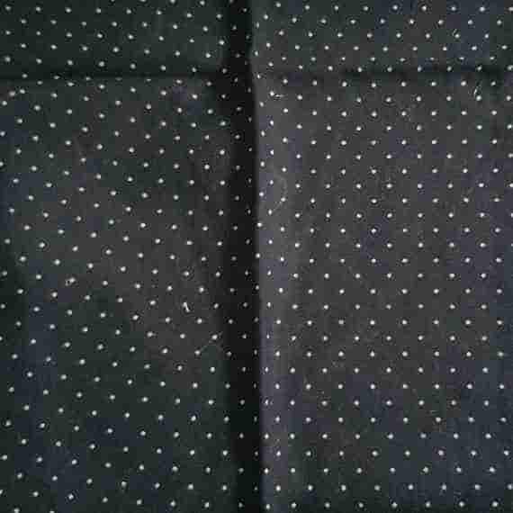 Black polka dot fabric with small white dots and a classic minimalist spotted pattern.