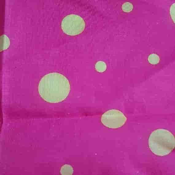 Hot pink polka dot fabric with pale yellow spots and a bold, cheerful dotted pattern.