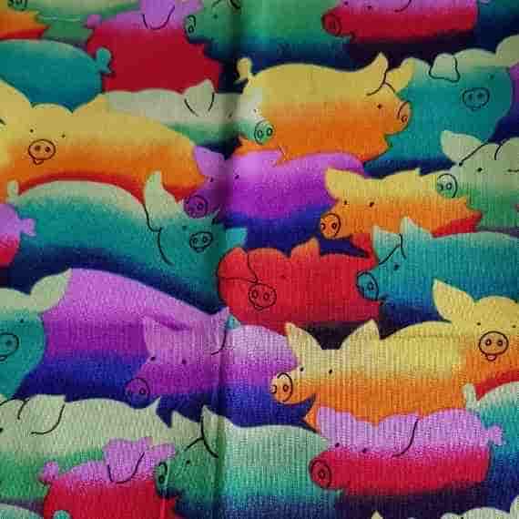 Bright colourful pig fabric with rainbow-style pig illustrations in red, yellow, green, blue and purple for a fun playful pattern.