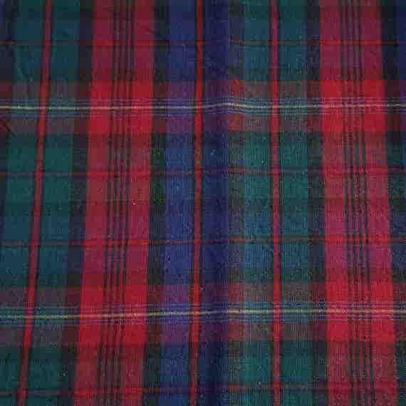 Classic tartan fabric with red, green, navy and black checks in a traditional woven plaid pattern.