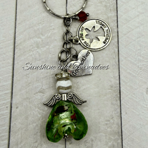 Handmade green lampwork glass heart angel keyring with silver-tone wings, white marbled bead, rhinestone spacer, stainless steel keyring, heart charm engraved "Godmother" and "You Are My Guardian Angel" charm, displayed on a rustic wooden background.