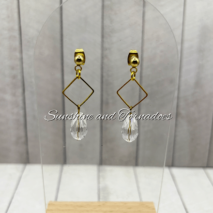 Handmade gold geometric earrings featuring elegant diamond-shaped frames and faceted crystal drop pendants, creating lightweight contemporary jewellery with a sophisticated sparkle for special occasions and everyday wear.