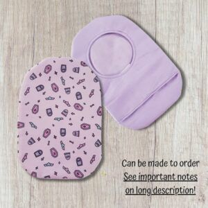 Two handmade stoma bag covers on a wooden background, showing a cute goth patterned front cover with coffins, bats, bones and stars, alongside a soft lilac reverse cover with an opening.
