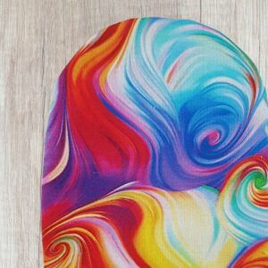 Handmade rainbow marbled stoma bag cover with colourful swirl fabric in red, blue, yellow, pink and turquoise, shown close up on a wooden background.