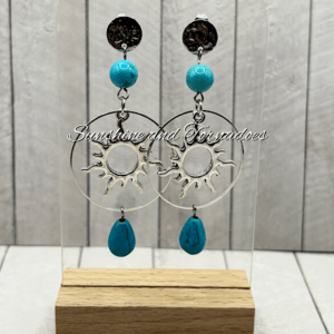 Handmade turquoise howlite gemstone earrings featuring silver-tone celestial sun charms, circular hoops and turquoise gemstone drops, creating elegant boho statement jewellery perfect for summer and festival wear.