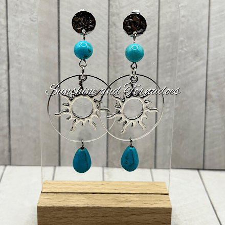 Handmade turquoise howlite gemstone earrings featuring silver-tone celestial sun charms, circular hoops and turquoise gemstone drops, creating elegant boho statement jewellery perfect for summer and festival wear.